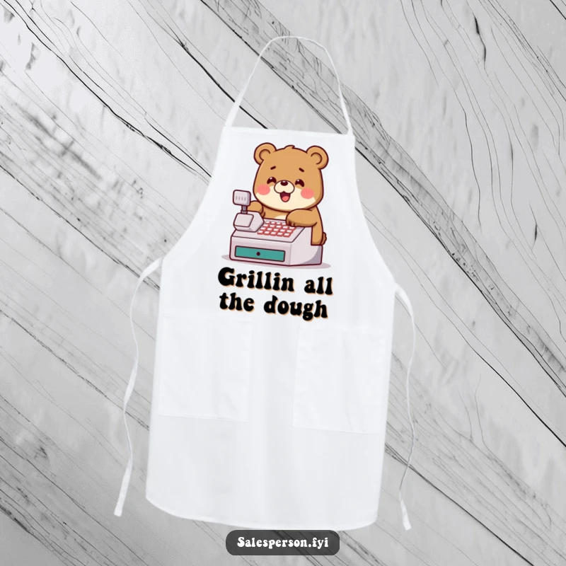 Funny apron with a jovial bear tapping a cash register, adding humor to kitchen duties.